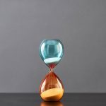 Ampoule en verre avec sable coloré bleu et orange, décoration scientifique élégante, idéale pour un intérieur moderne ou un espace de bureau inspirant.