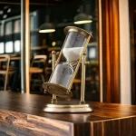 Sablier décoratif en métal vintage avec verre transparent, idéal pour la décoration intérieure ou comme objet de collection.