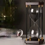 Sablier scientifique en verre avec cadre en bois et éléments métalliques dorés, idéal pour la décoration de bureau ou d'étagère avec un style industriel ou scientifique.