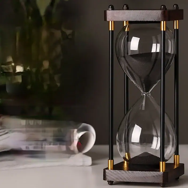 sablier-en-bois-60-minutes-1 Sablier scientifique en verre avec cadre en bois et éléments métalliques dorés, idéal pour la décoration de bureau ou d'étagère avec un style industriel ou scientifique.