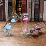 Horloges de sable en verre avec poudres colorées roses, bleues et violettes, utilisées comme décoration scientifique ou pour la mesure du temps.