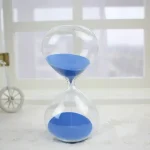 Sablier de laboratoire avec sable bleu, symbole de la mesure du temps, idéal pour la décoration scientifique ou éducative.