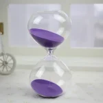 Sablier scientifique avec sable violet, symbole de la mesure du temps, idéal pour la décoration de bureau ou d'études, apportant une touche scientifique et élégante.