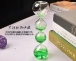 Pied à verre en verre avec deux boules transparentes et liquide vert, parfait pour la décoration scientifique ou comme objet de collection.