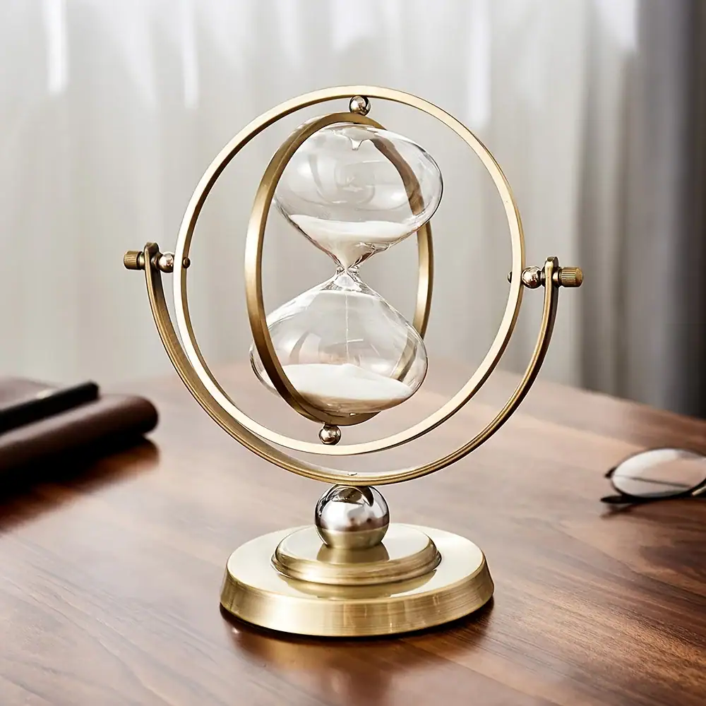 sablier-rotatif-en-metal-dore-1 Sablier scientifique décoratif en métal doré avec deux ampoules de verre, symbole du temps et de la science, idéal pour la décoration de bureau ou d'étagère.