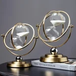 Horloge décorative en forme de sablier avec sphères en verre et structure en métal doré, inspirée du style astronomique, idéale pour la décoration intérieure.