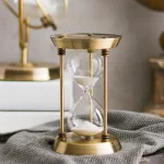 Sablier en métal vintage avec cadre en laiton et verre, décoratif pour une décoration scientifique ou vintage.