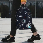 Sac à dos avec motif d'espace et de galaxies, parfait pour les amateurs d'astronomie et de décoration scientifique.