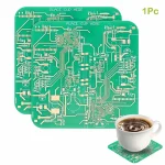 Plaque de circuit électronique verte pour décoration de laboratoire ou d'atelier scientifique, accompagnée d'une tasse de café sur une plaque en circuit imprimé.