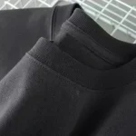 T-shirt noir en coton biologique, simple et élégant, parfait pour un style décontracté ou casual, fabriqué à partir de matériaux durables pour un confort optimal.