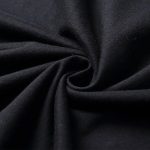 Échantillon de tissu noir enroulé, montrant sa texture douce et fluide, idéal pour la décoration ou la couture.