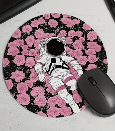 Vêtement d'astronaute illustré posé sur un tapis rond à motif de roses roses et noires, avec une souris d'ordinateur noire à côté.