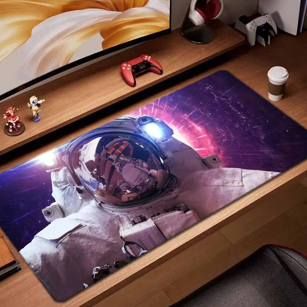 tapis-de-souris-large-espace-1 Panneau de bureau avec tapis de souris représentant un astronaute dans l'espace, entouré de figurines et d'objets liés à la science et à la technologie.