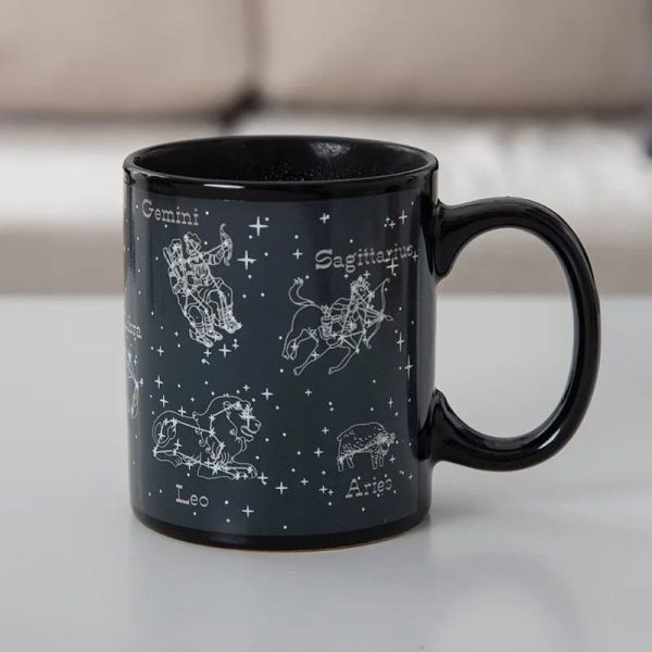 Mug en céramique noir avec illustrations des constellations du zodiaque : Gémeaux, Sagittaire, Lion, Bélier, et plus, avec noms en français.