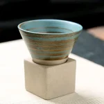 Coupe en céramique avec motifs géométriques, posée sur un socle en béton, idéale pour la décoration scientifique ou pour une collection d'objets décoratifs.