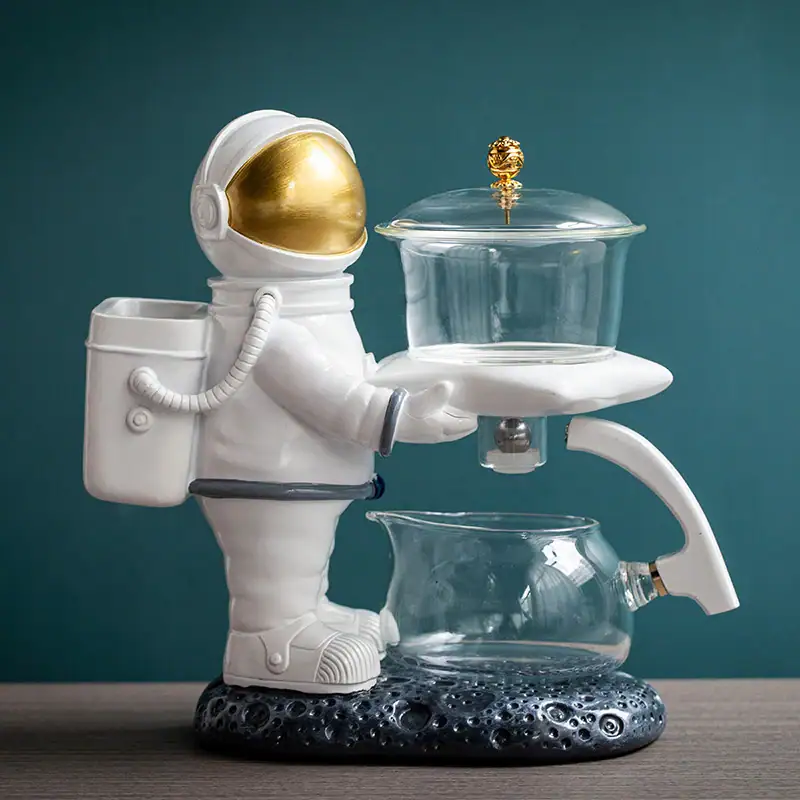 theiere-alimentee-astronaute-avec-6-verres-1 Figurine d'astronaute en plastique blanc avec un laboratoire de laboratoire en verre, décoration de style scientifique et spatial.