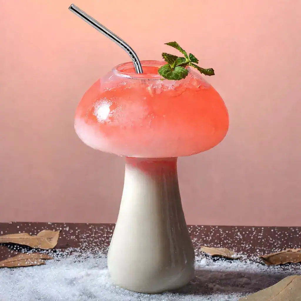 verre-a-cocktail-champignon-1 Verre en forme de champignon contenant un cocktail rose avec une branche de menthe, décoratif et original.
