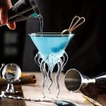 Vase en verre transparent avec support en forme de tentacules, idéal pour décoration scientifique ou moderne.