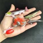 Collection de figurines de poissons et créatures marines en plastique coloré, idéales pour la décoration scientifique ou éducative.