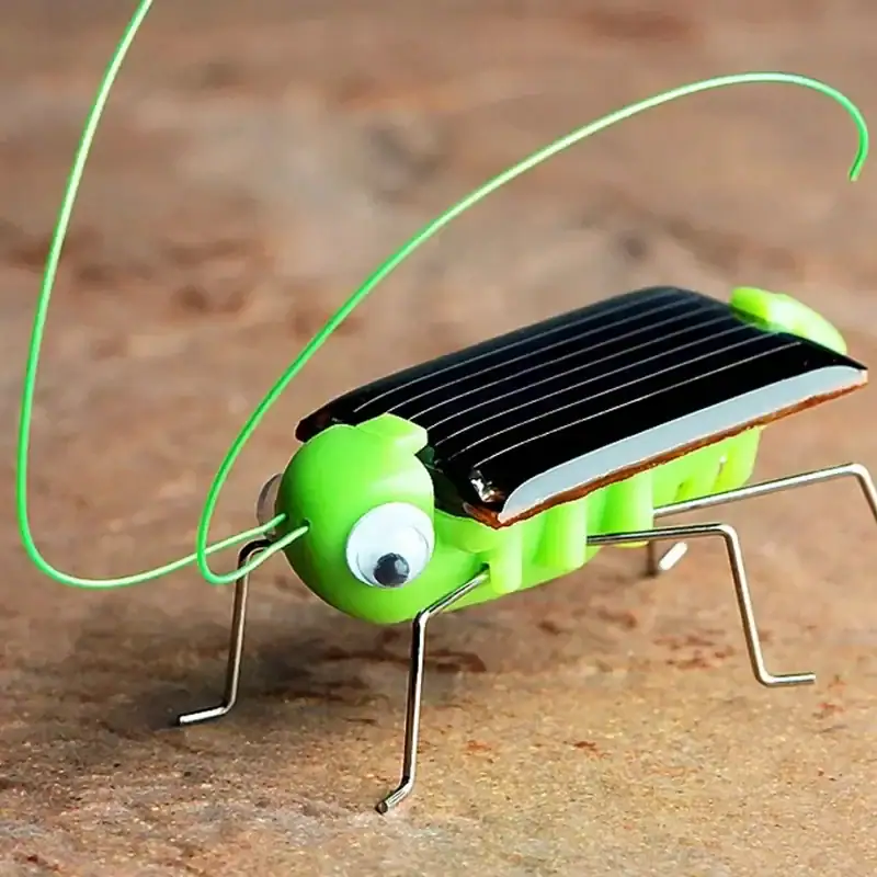 insecte-solaire-1 Puce solaire en forme d'insecte avec corps en métal, ailes en plastique noir, et yeux en plastique blanc avec pupilles noires.