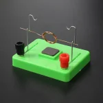 Puce de démonstration de circuit électrique avec bobine, aimants et bornes pour expériences scientifiques.