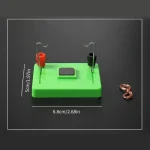 Puce de démonstration de circuit électrique avec fils, aimants et base en plastique vert, utilisée pour des expériences scientifiques éducatives.