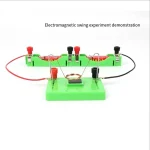 Dispositif éducatif illustrant une expérience d'oscillation électromagnétique avec bobines, aimants et fils connectés sur une base verte.