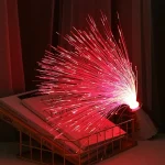 Pétard de fibre optique rouge brillant, créant un effet de feu d'artifice, posé sur une étagère avec des livres, ambiance chaleureuse et moderne.
