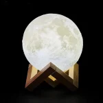 Lampe lune 3D réaliste sur support en bois, éclairage doux, décoration d'intérieur inspirée de l'astronomie, idéale pour une ambiance chaleureuse et cosmique.