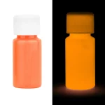 Flacon de peinture fluorescente orange visible en lumière normale et luminescente dans l'obscurité, parfait pour décoration ou projets artistiques lumineux.