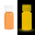 Pillules fluorescentes orange et jaune sous lumière noire, illustrant la fluorescence dans un environnement sombre.
