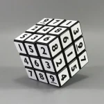 Cube numérique à 3x3 avec chiffres noirs sur fond blanc, utilisé comme objet décoratif ou éducatif, illustrant la science et la logique.