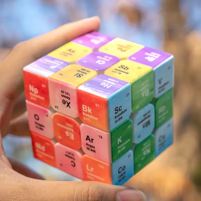 rubiks-cube-tableau-periodique-1 Cube de la table périodique des éléments avec des couleurs vives et des symboles chimiques.
