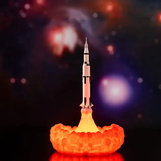 veilleuse-fusee-1 Fusée en lancement avec explosion de fumée orange, illustrant une expérience scientifique ou un modèle réduit de fusée dans un contexte éducatif ou décoratif.