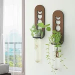 Support de plantes suspendu en verre avec cadre en bois, décoration moderne pour intérieur.