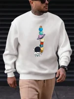 Sweat-shirt avec illustration d'un explorateur spatial regardant une tour de planètes en équilibre.