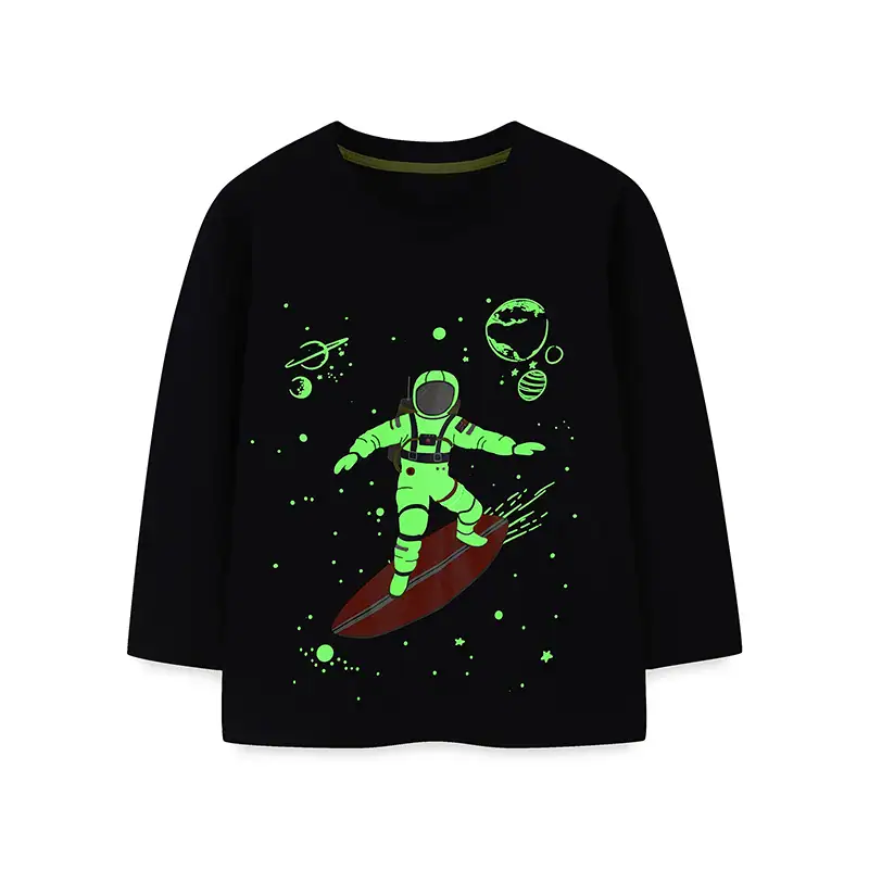 pull-enfant-astronaute-surfer-1 Sweat-shirt noir avec illustration d'un enfant en combinaison spatiale sur une planche de surf dans l'espace, entouré de planètes, étoiles et météores.