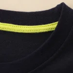 T-shirt noir avec bande réfléchissante jaune, idéal pour la sécurité et le sport, fabriqué en coton de haute qualité pour un confort optimal.