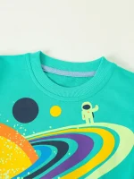 T-shirt pour enfant avec design d'astronaute et planètes colorées, idéal pour les amateurs d'espace et de science, parfait pour une décoration ludique et éducative.