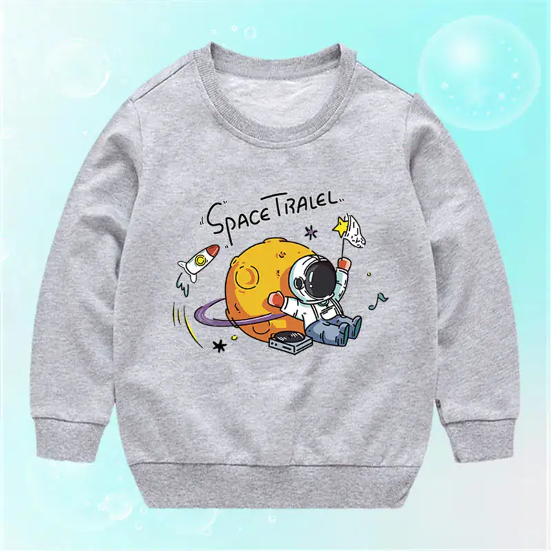pull-enfant-space-travel-1 Vêtement pour enfant gris avec motif d'un astronaute et d'une planète, inspiré de l'espace, parfait pour les amateurs de science et d'aventure spatiale.
