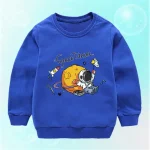 Vêtement pour enfant bleu avec motif d'astronaute et planètes, idéal pour les amateurs d'espace et de science.