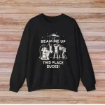 T-shirt noir avec illustration humoristique et texte "Beam me up, this place sucks!" pour les amateurs de science et d'humour.