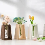 Vase en bois foncé, en céramique blanche et en céramique beige, chacun contenant des fleurs artificielles colorées, parfaits pour la décoration intérieure élégante.