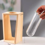 Support en bois pour tube à essai, parfait pour expériences scientifiques et activités éducatives. Dimensions : 18 cm de hauteur, 10 cm de largeur, 7,5 cm de profondeur.
