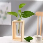 Vase en bois avec une plante verte à feuilles larges dans un intérieur moderne, décoration naturelle et élégante.