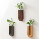 Trois vases en bois suspendus avec des plantes vertes, décoration moderne et naturelle pour intérieur.